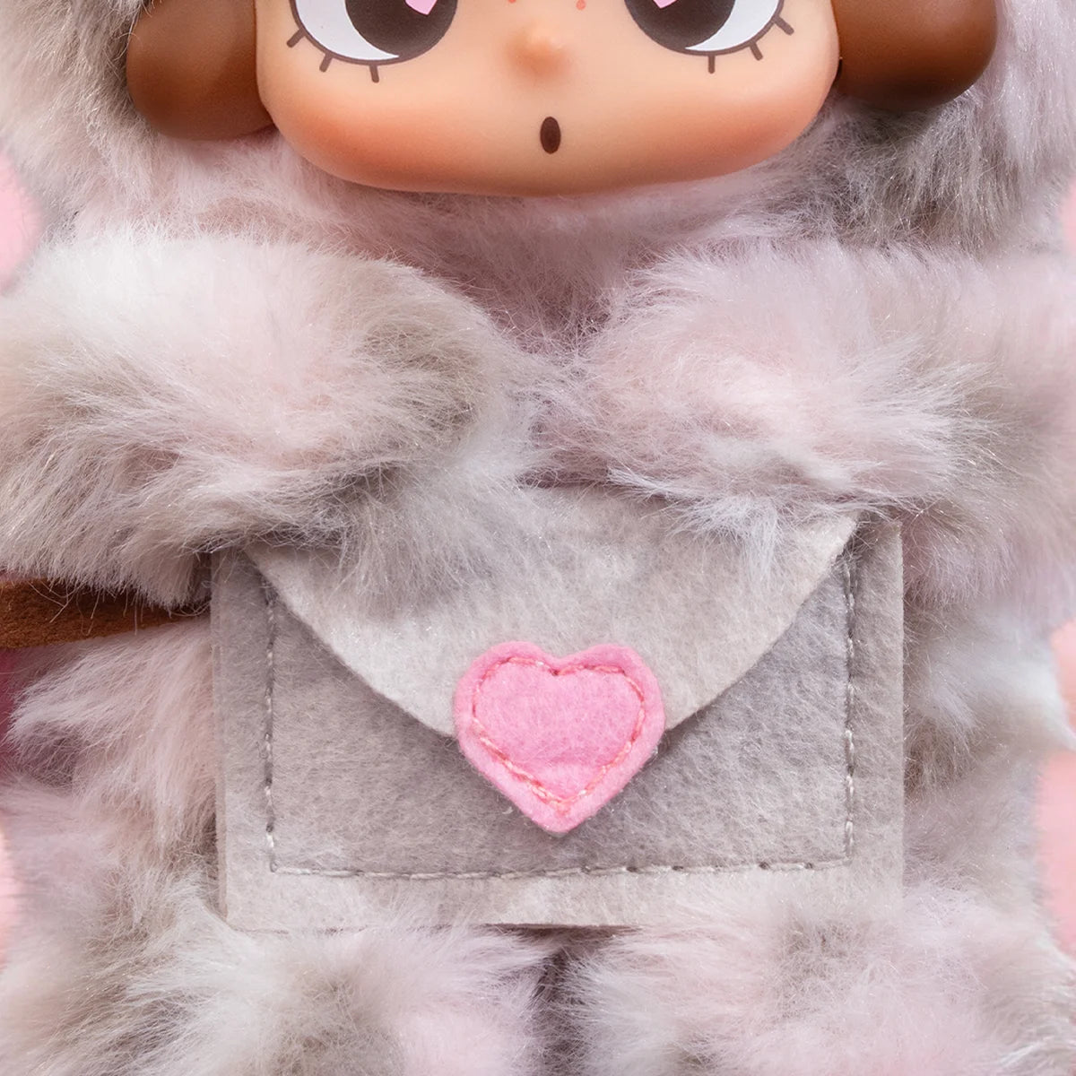 Close-up of CiCiLu messenger plush grey envelope pocket with pink heart on chest