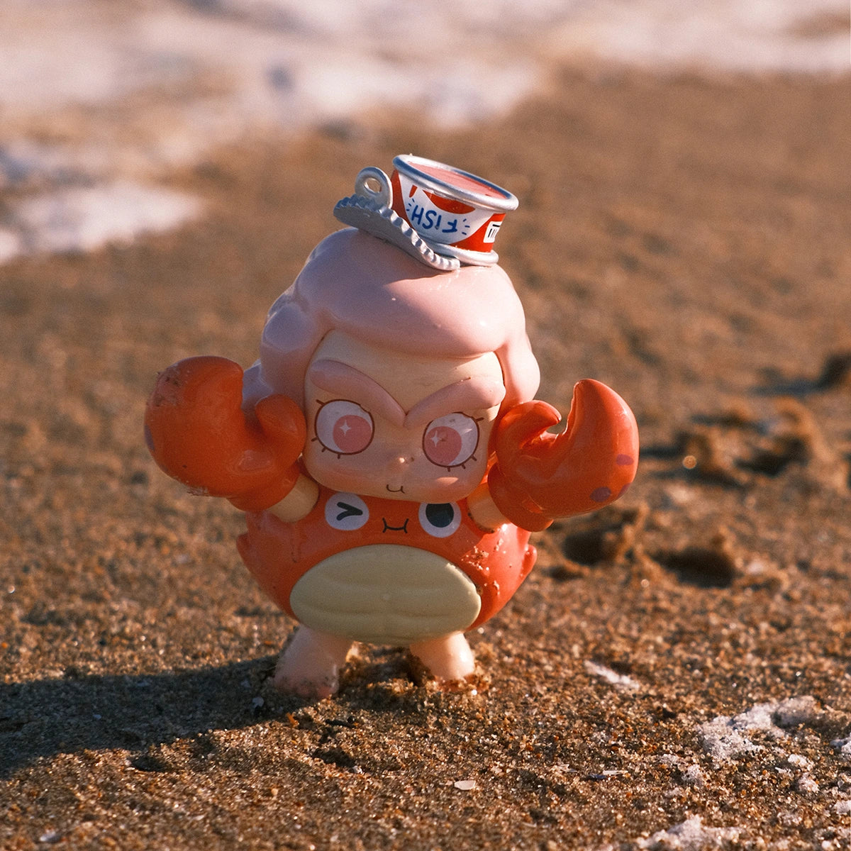 CiCiLu in an orange crab costume with sailor hat and claws standing on wet beach sand