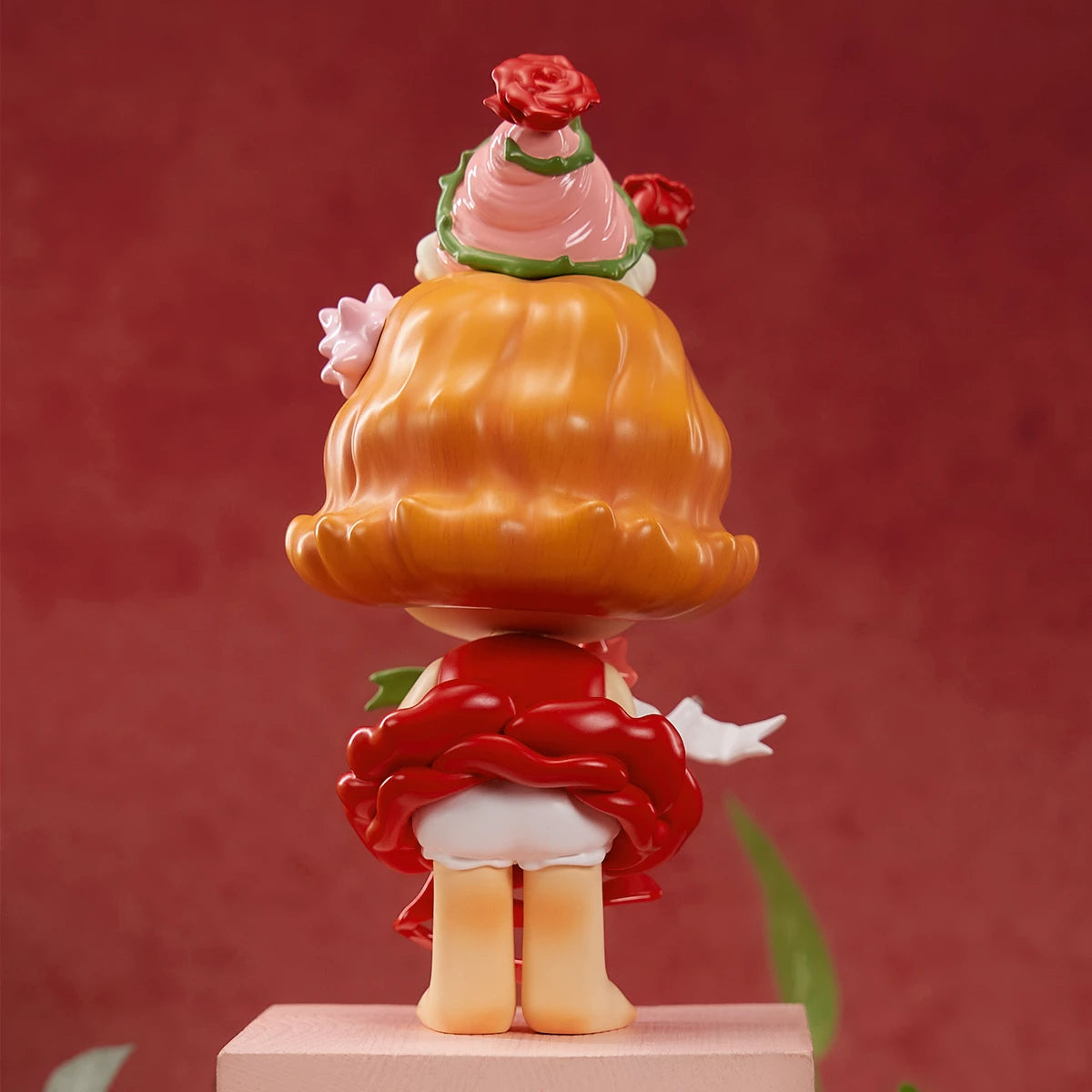 Back view of CiCiLu Urchin Oh My Love figure showing wavy hair and rose dessert hat