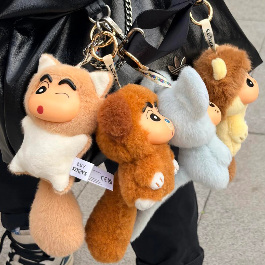 Three Shinchan Big Tails plush keychains in cat, dog, and mouse costumes hanging from a black bag