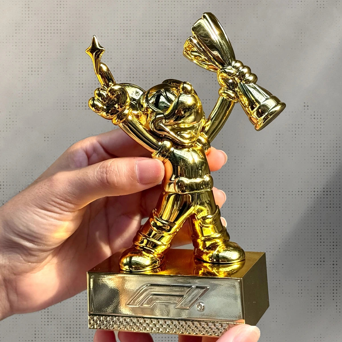 Hand holding the secret gold Mickey Mouse F1 champion trophy