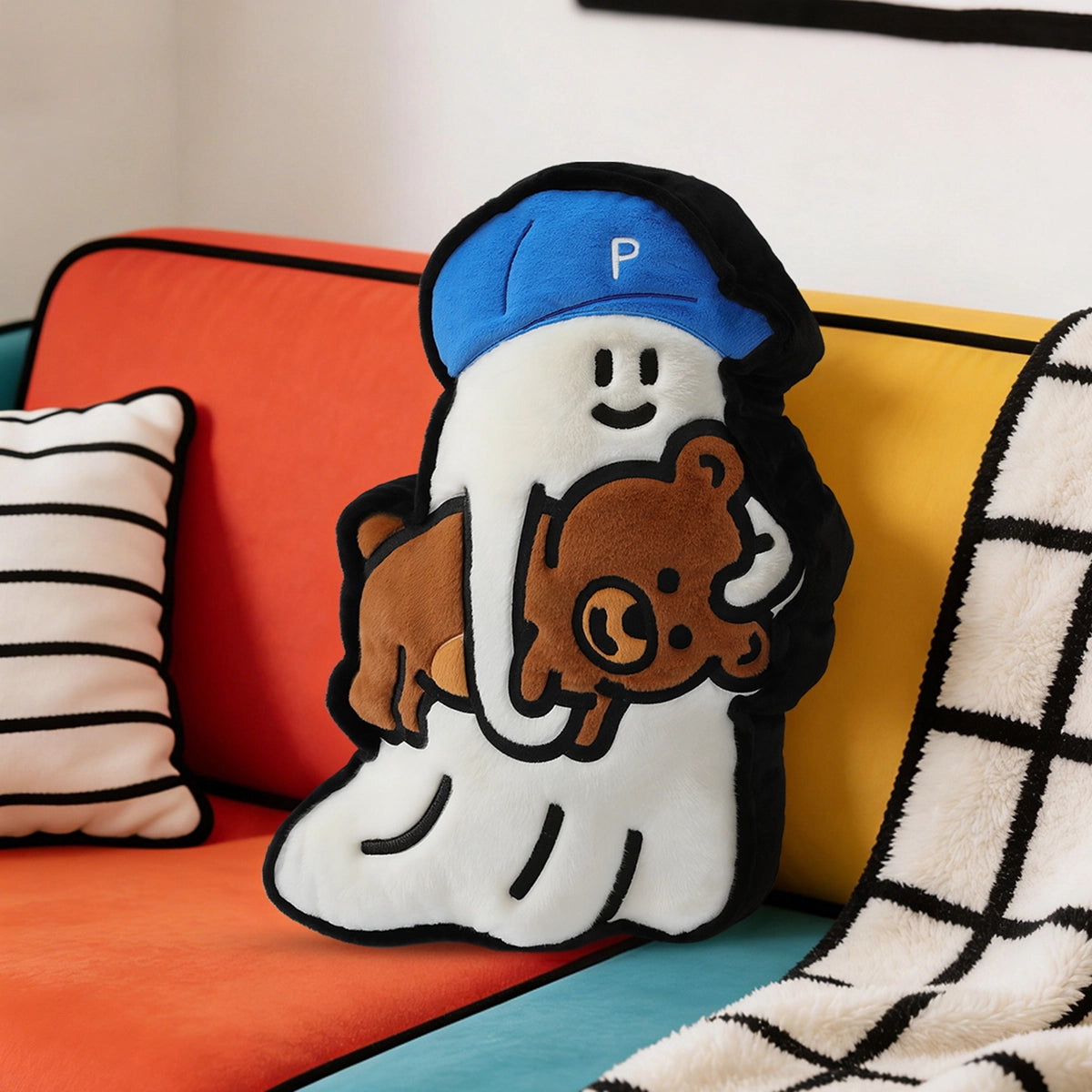 Ghody City Walk ghost-in-cap plush pillow hugging a teddy bear, styled on a colorful sofa