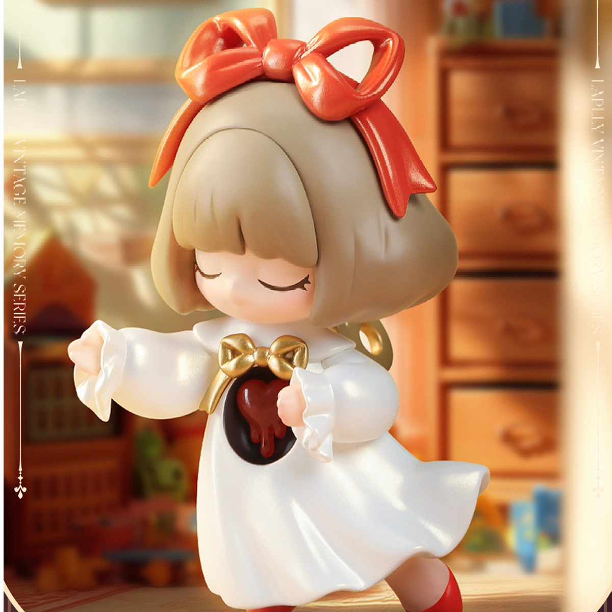 The Wind-up Ballerina Laplly in white dress with orange bow holding a dripping-heart locket, Laplly Vintage Memory