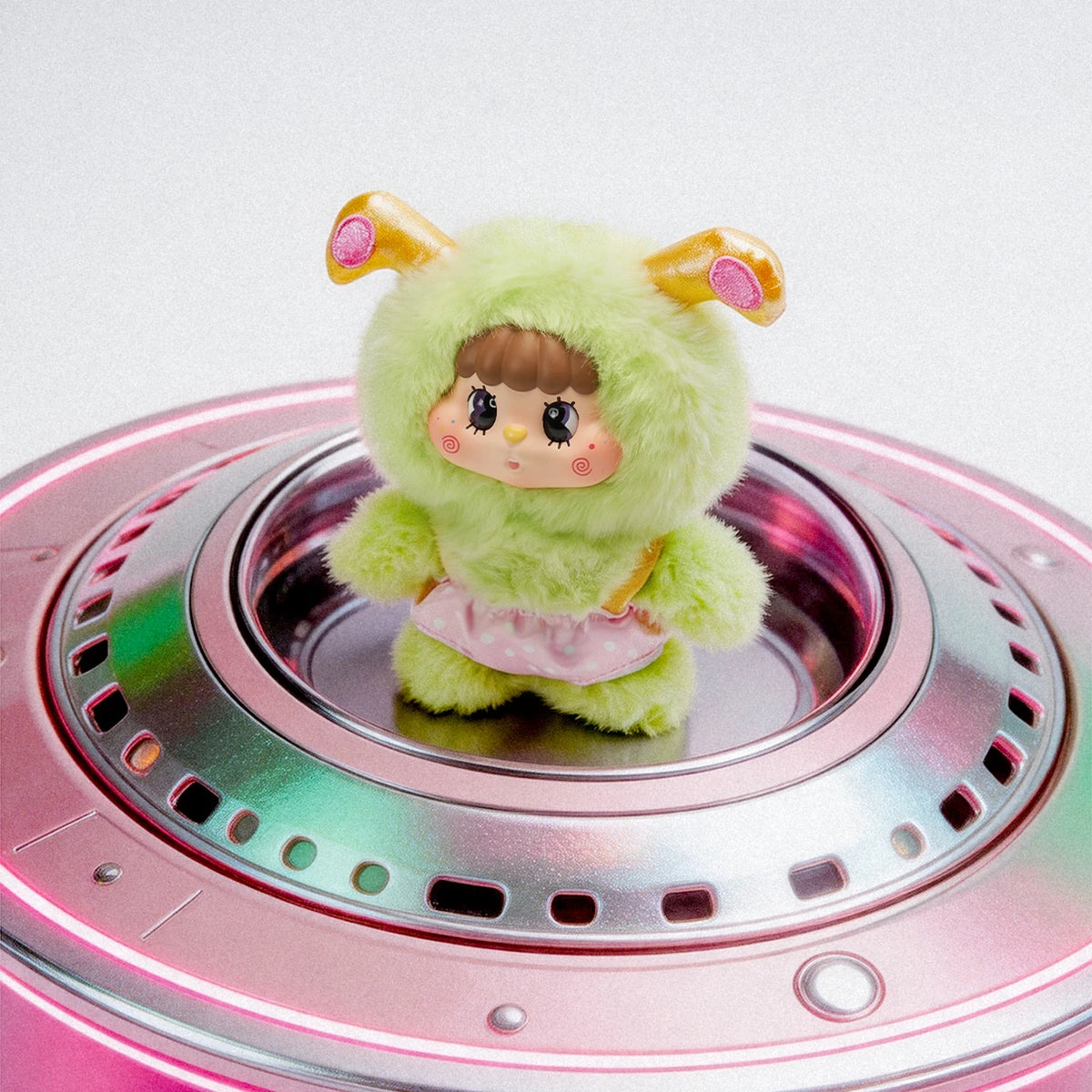 Little Buns green alien-cat plush standing on a silver flying-saucer prop
