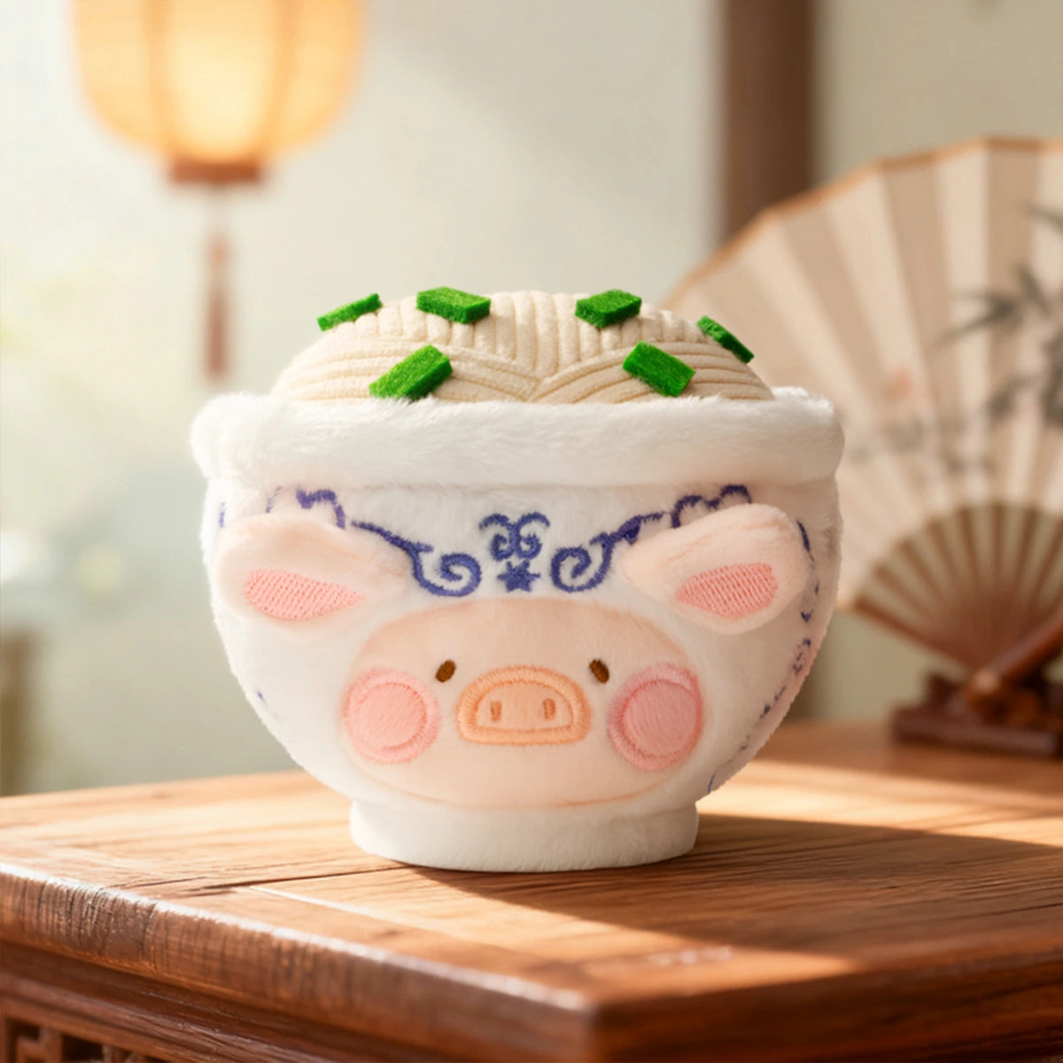 Big Bowl Noodles piggy in a white-and-blue bowl topped with noodles and greens, Lulu The Piggy Food Hunter
