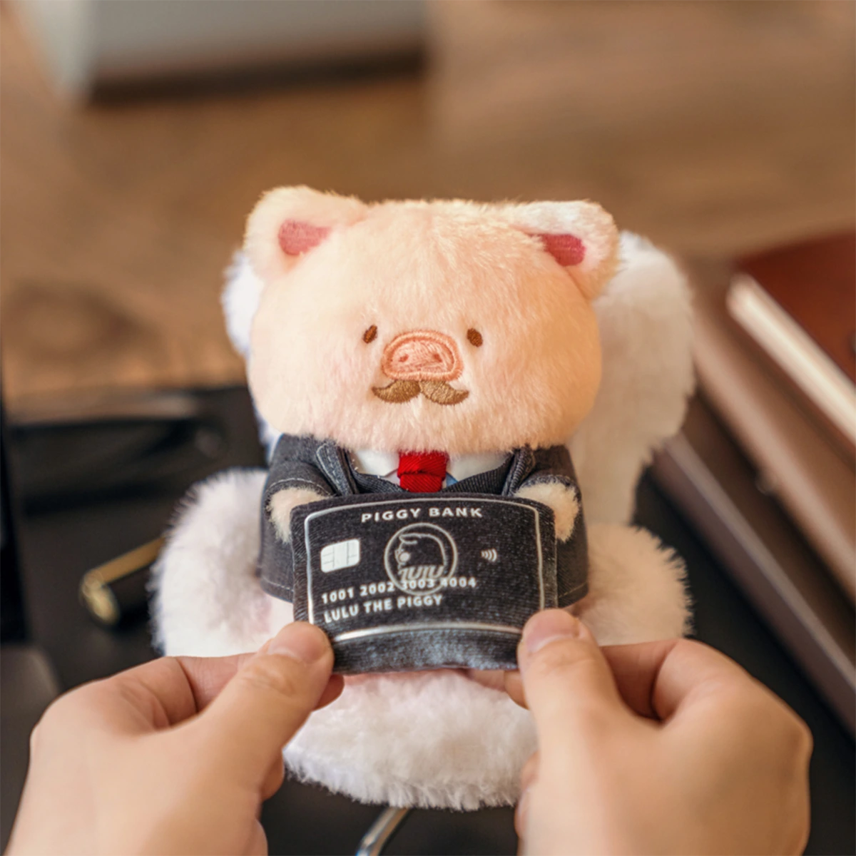 I Quit Lu suited piggy plush keychain holding a black PIGGY BANK card, LuLu Piggy Office