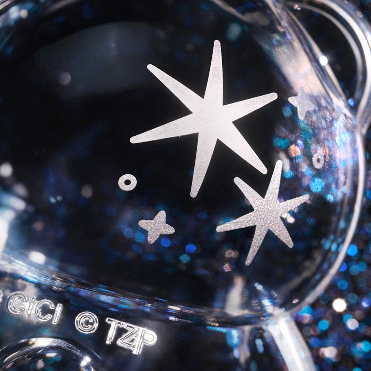 Close-up of a clear glittery Lulu piggy figure with silver star detailing, Teddy Mini Ore Collection