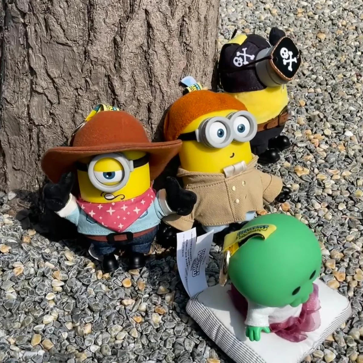 Cowboy James, Artist Henry, Pirate Carl, and Goomi plush toys posed at the base of a tree