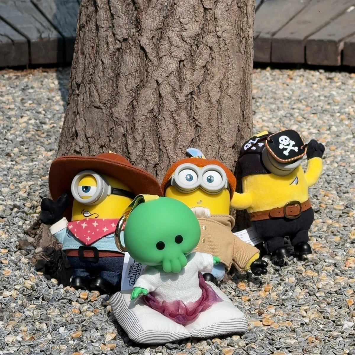 Goomi, Cowboy James, Artist Henry, and Pirate Carl plush toys gathered around a tree