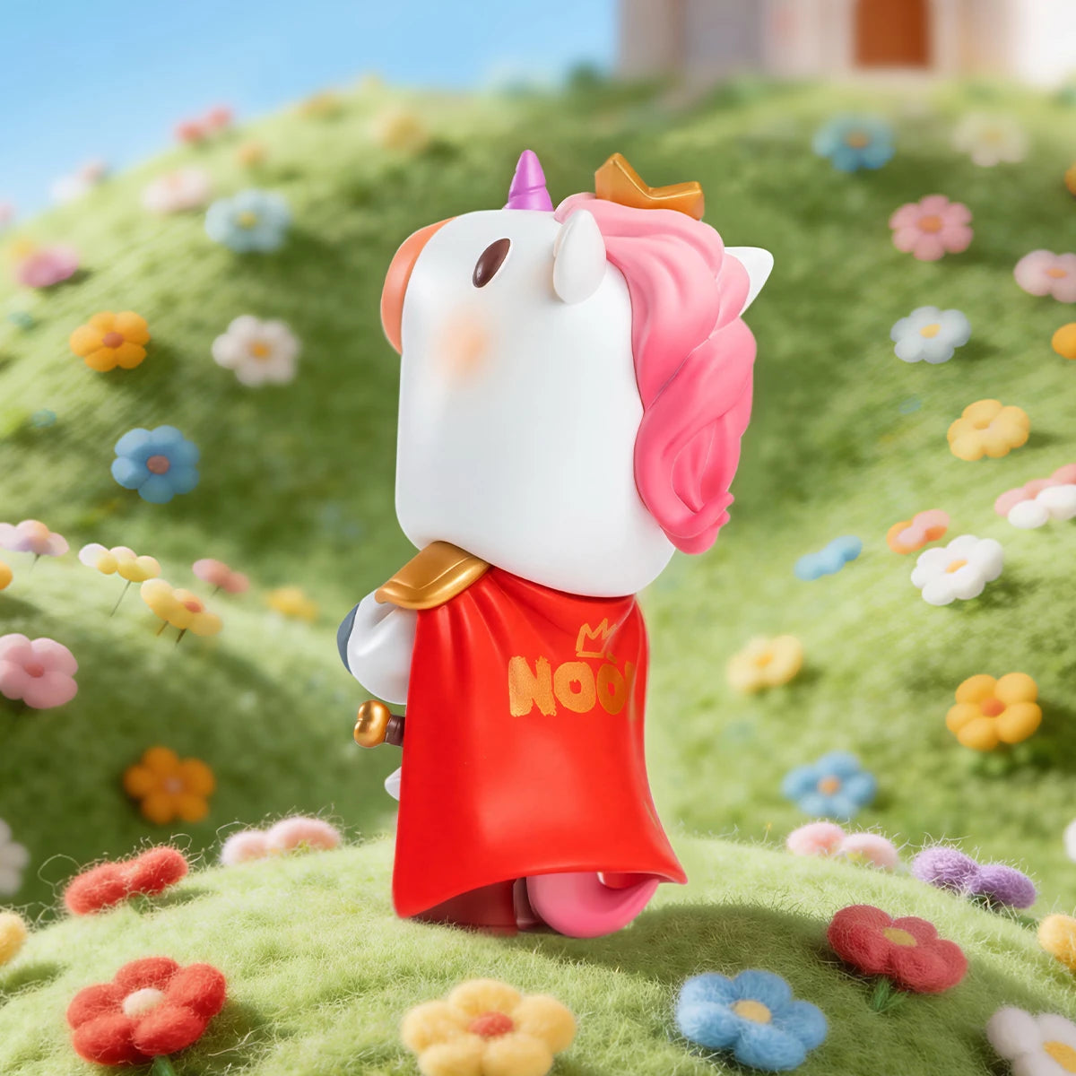 Back of NOOK Little Knight showing pink unicorn mane and red NOOK cape on a flowery hill, Wish Island edition