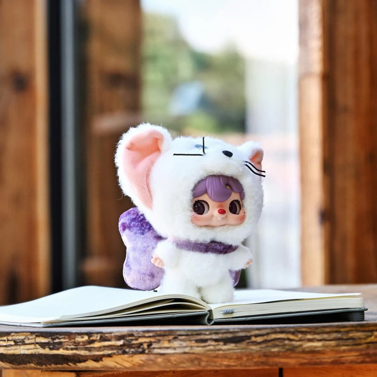 POUKAPOUKA white Tom costume standing on an open book
