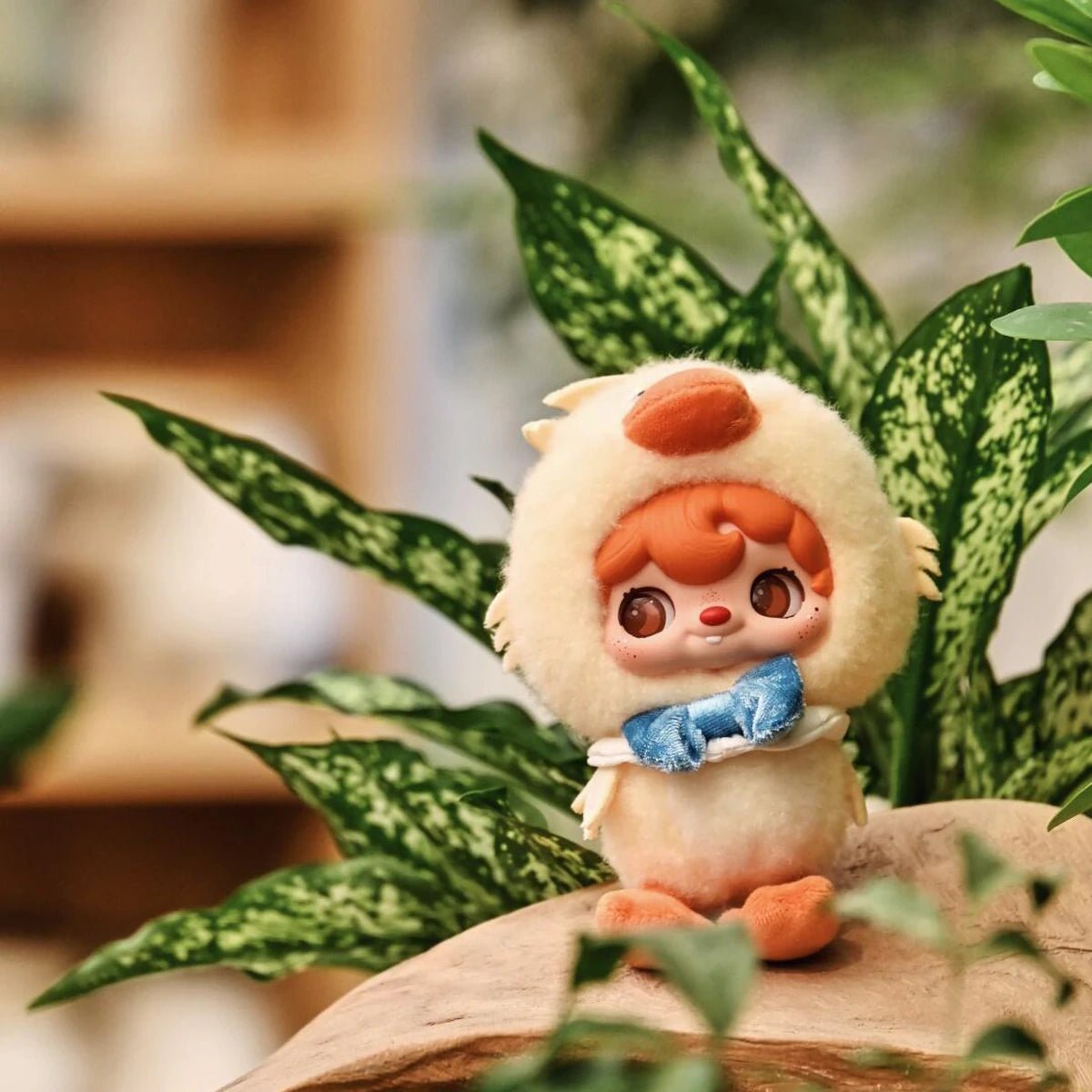POUKAPOUKA in a Quacker duck costume standing among houseplants