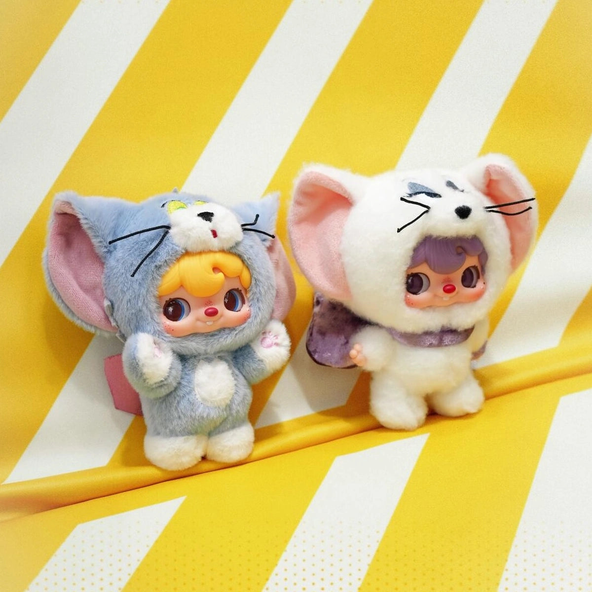 POUKAPOUKA gray Tom and white Tom costume plush toys on a yellow striped display