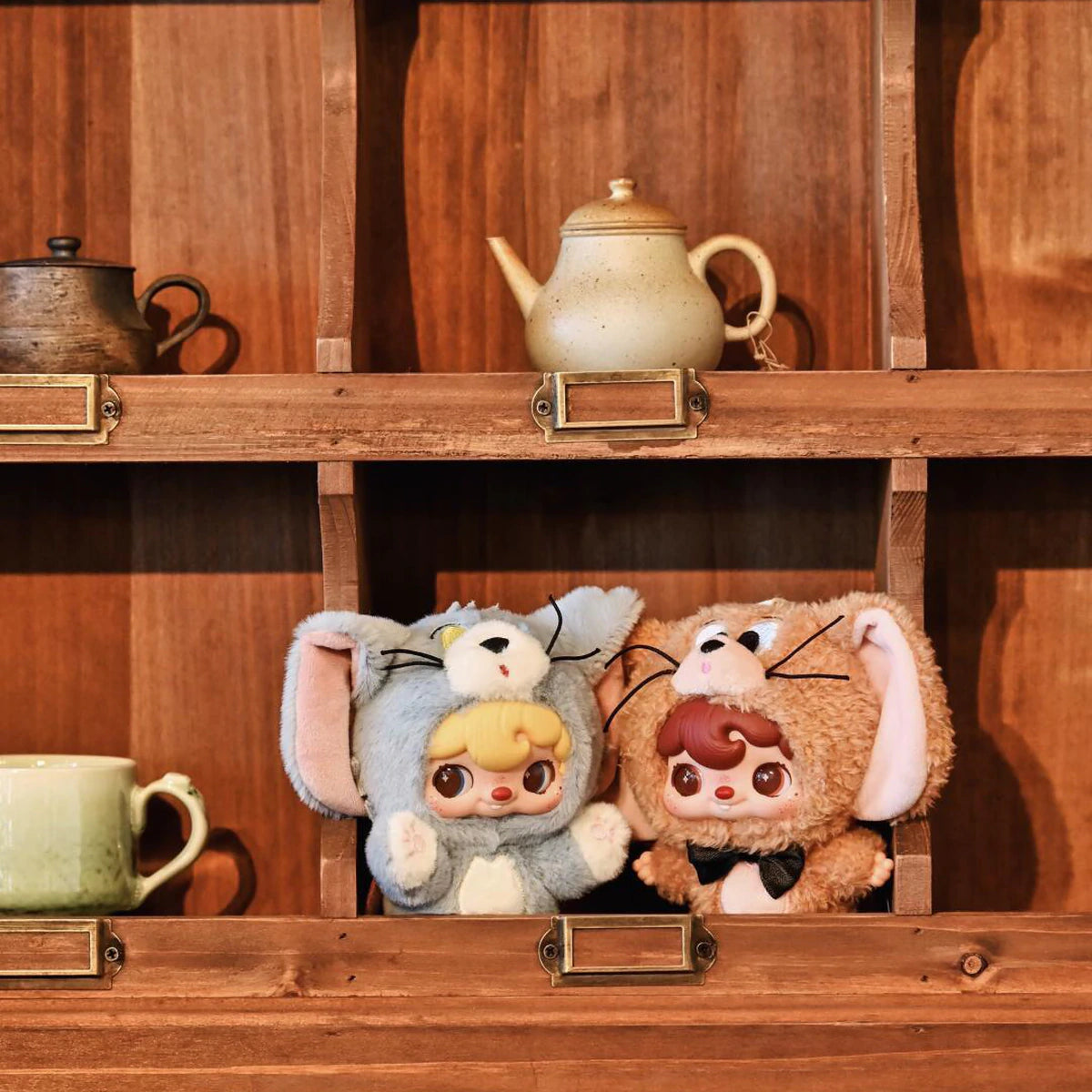 POUKAPOUKA gray Tom and brown Jerry costume plush toys displayed in wooden cubbies