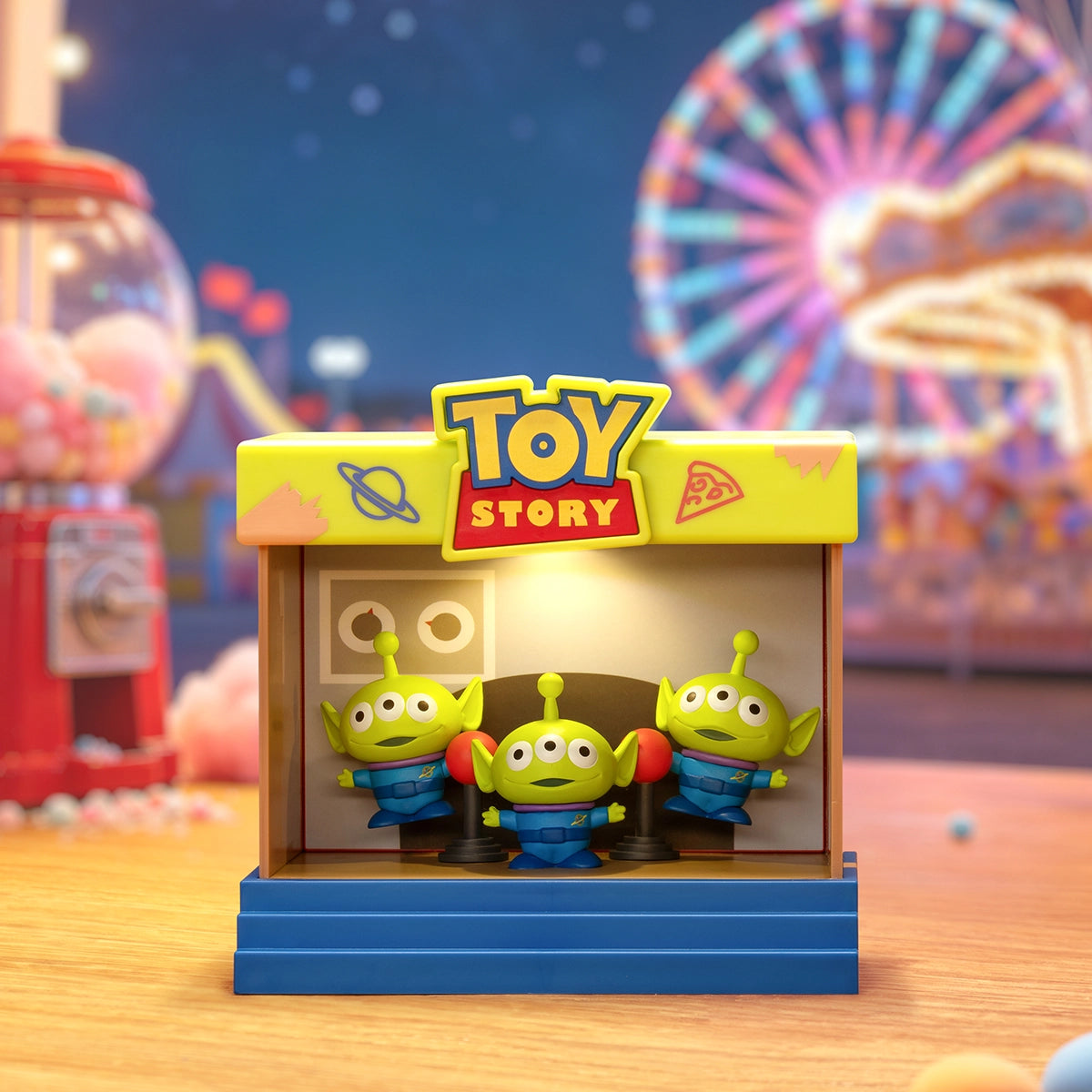 Three Toy Story Aliens standing together inside an arcade stage frame