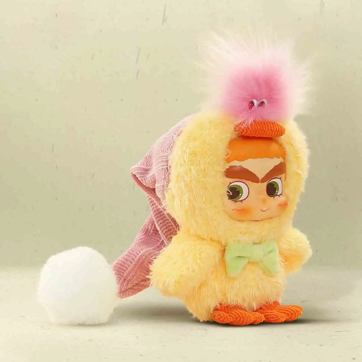 Side view of CICILU Huggy Ducky plush in yellow duck hood with white pom-pom tail and orange webbed feet