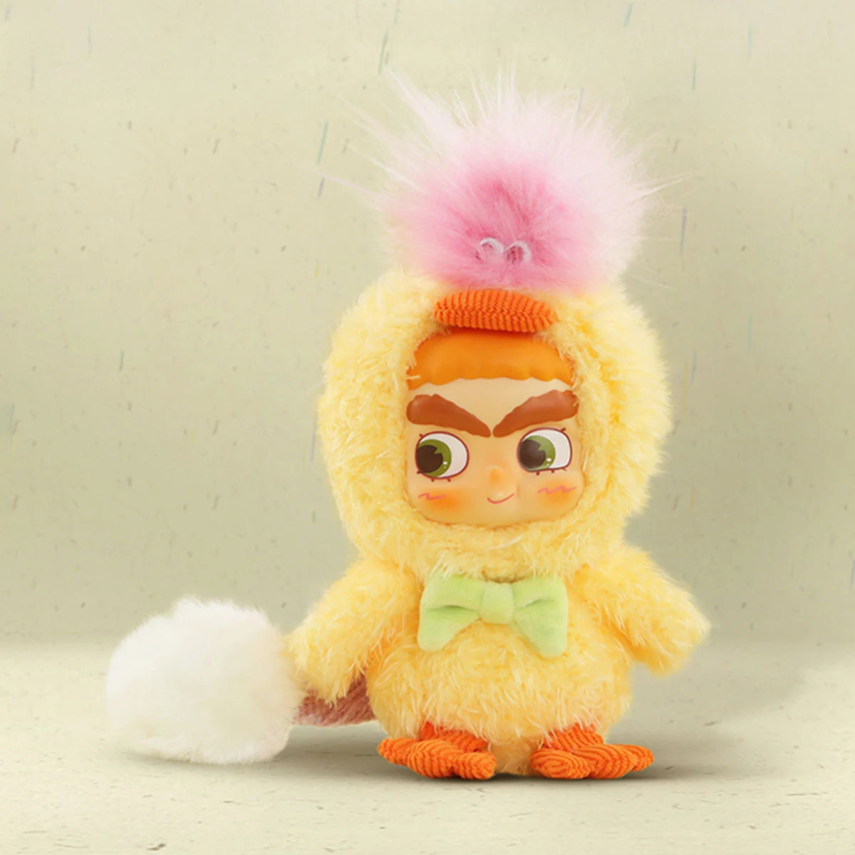 Front view of CICILU Huggy Ducky plush keychain, yellow duck costume with green bow and pink feather tuft