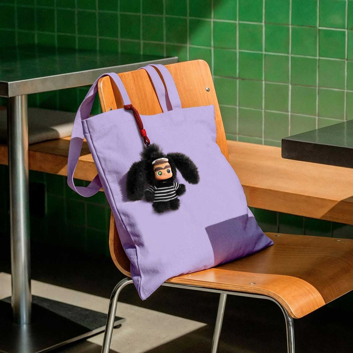CiCiLu Crazy Big Tooth Rabbit plush keychain attached to a lavender tote bag