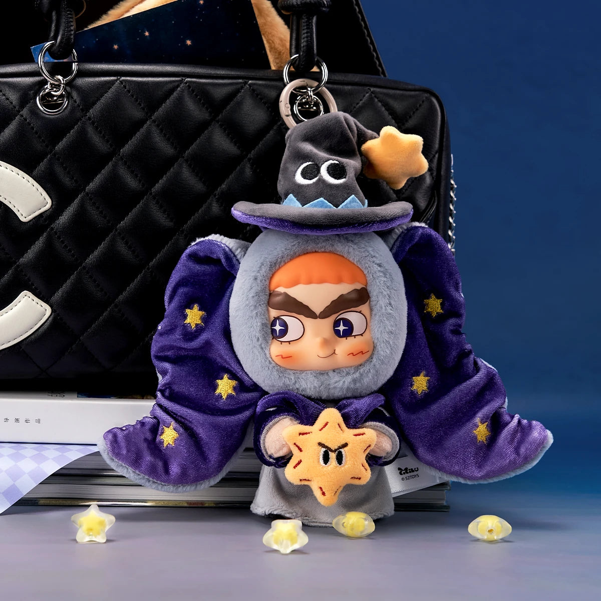 CiCiLu Star Elephant plush keychain clipped onto a quilted handbag as a bag charm, by 52TOYS