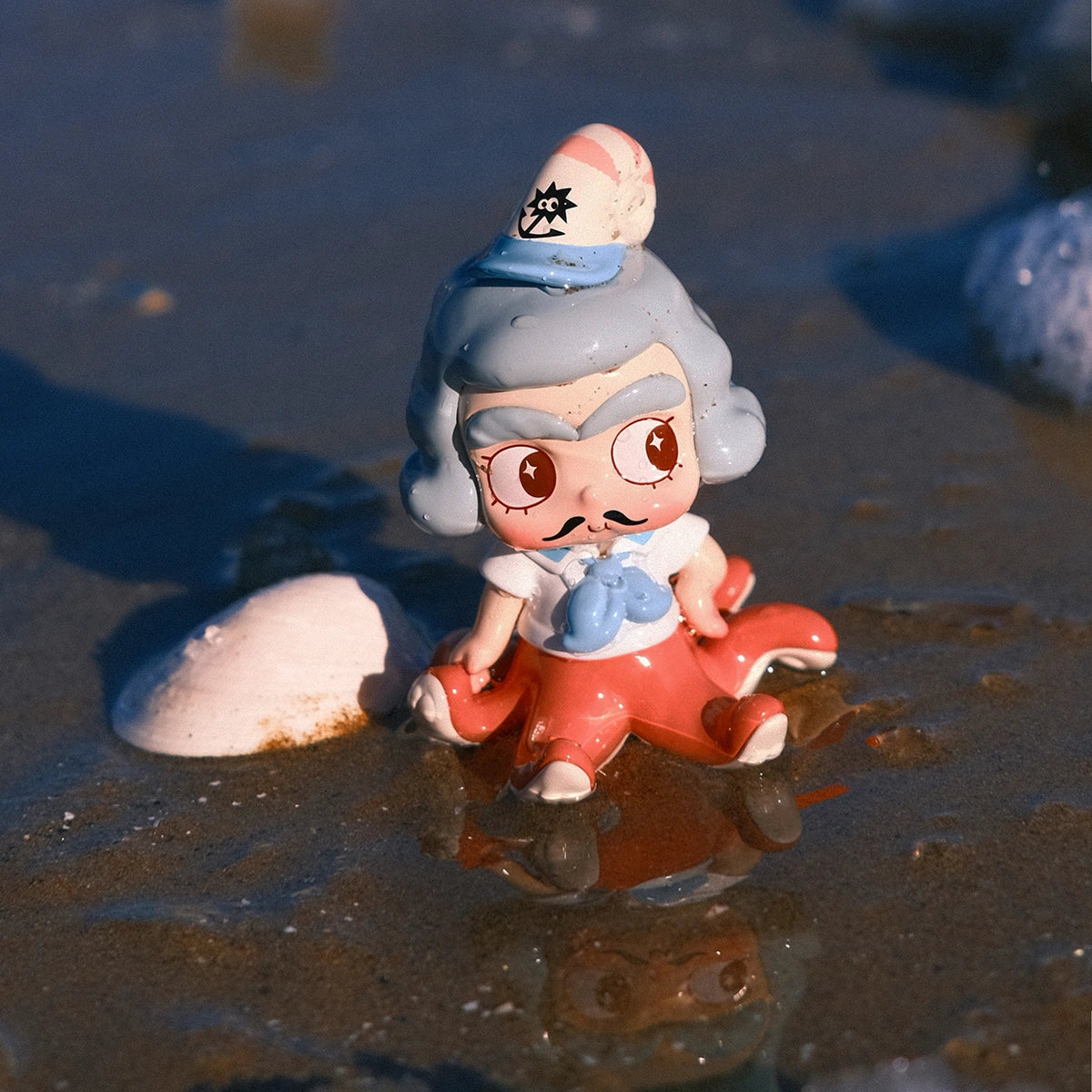 Blue-haired CiCiLu in an octopus-inspired sea cap seated in shallow ocean water
