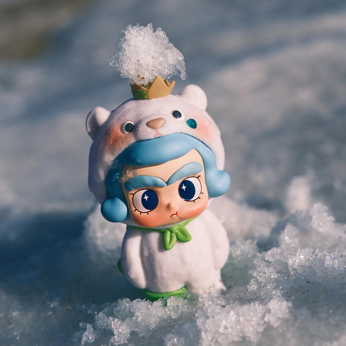 CiCiLu in a white seal costume with blue hair and green scarf surrounded by sea foam