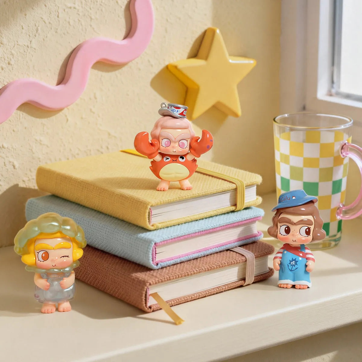 CiCiLu The Tide Shop figures Crabbing You, Pearl of Time and Cheeky Baby on Duty styled on stacked books