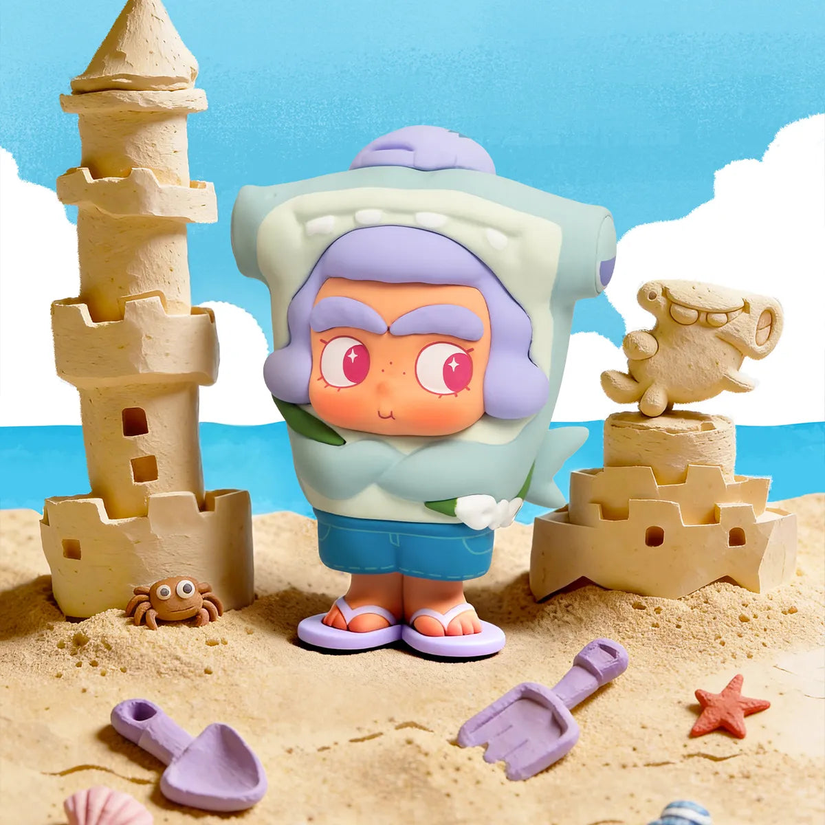 Hammerhead Cutie in grey-green shark hood and blue shorts with flip-flops by a sandcastle, CiCiLu The Tide Shop