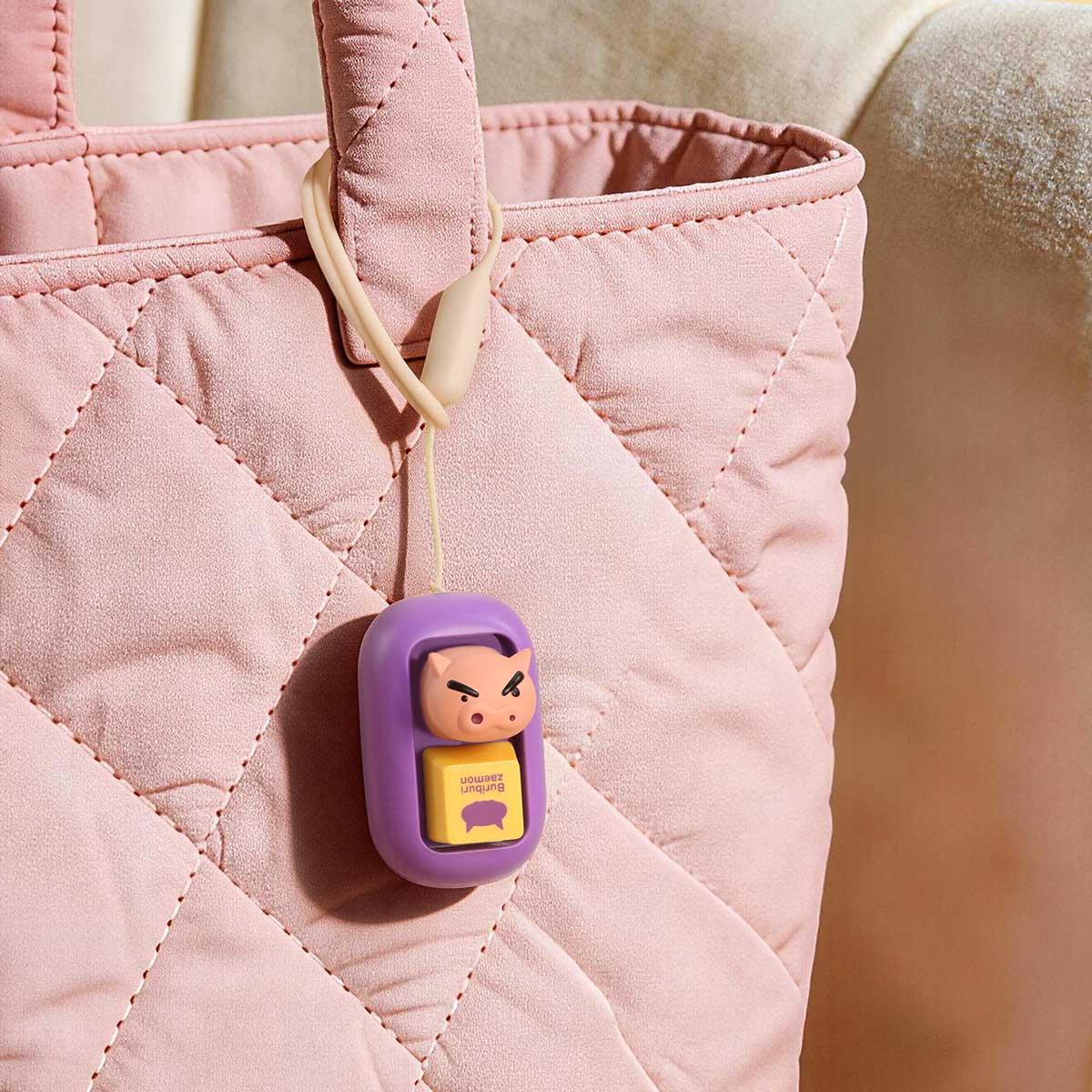 BuriBuriZaemon keycap charm clipped to a pink quilted bag, Crayon Shinchan Tap & Relieve Series