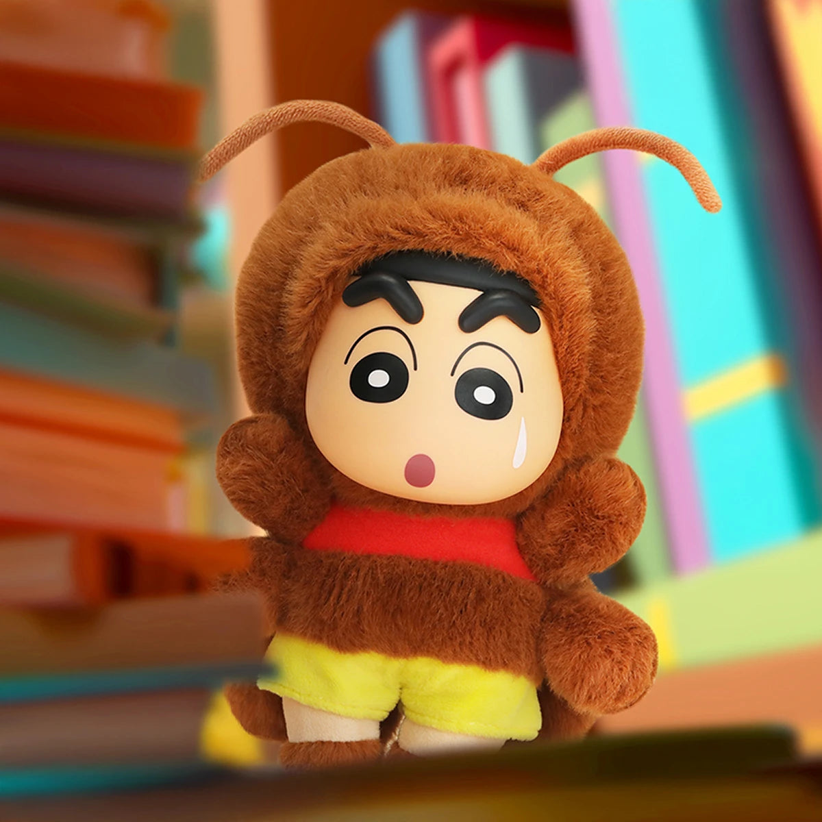 Crayon Shinchan cockroach plush keychain beside stacked books, Here Comes Your Johnny