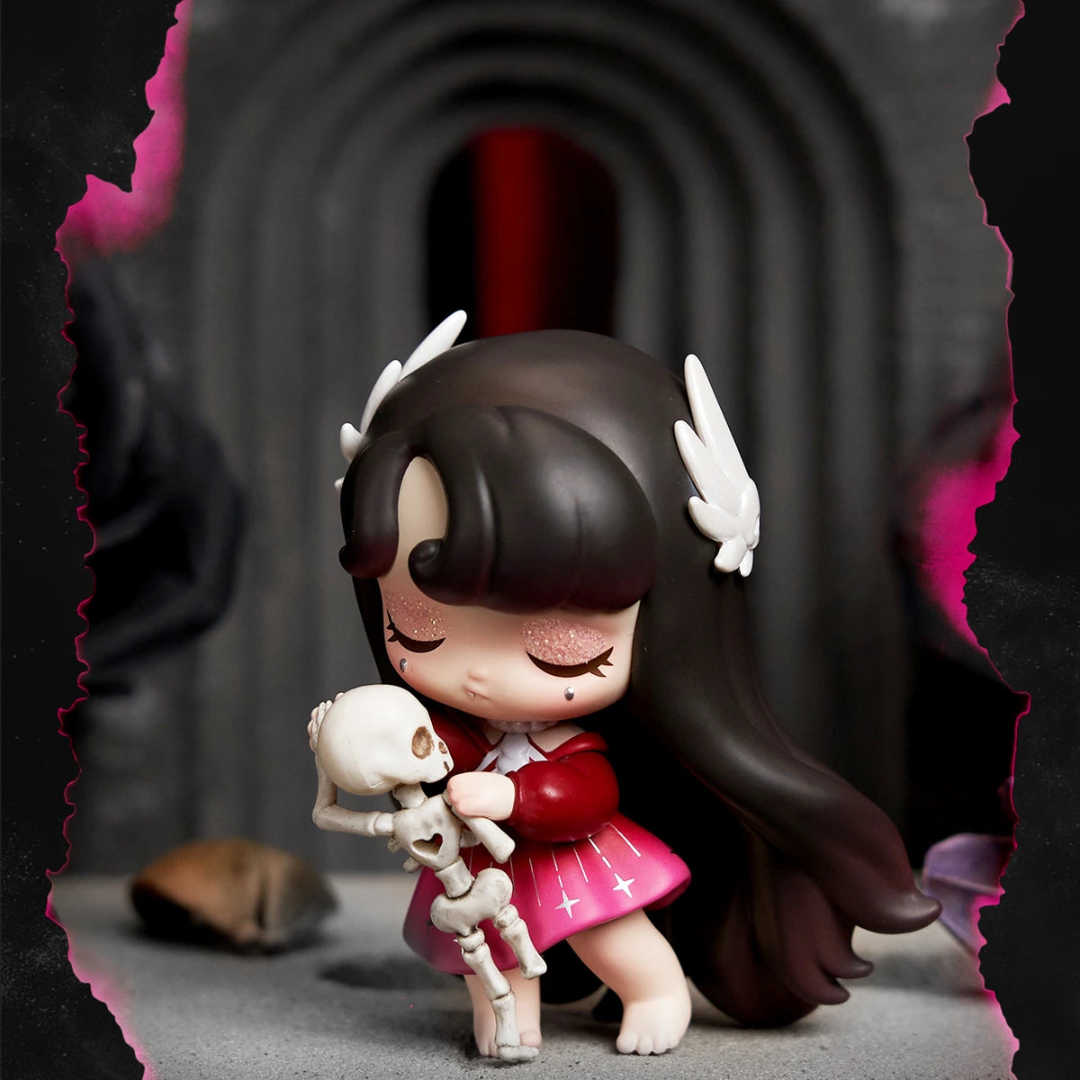 Brunette Lilith in a red dress embracing a small skeleton figure