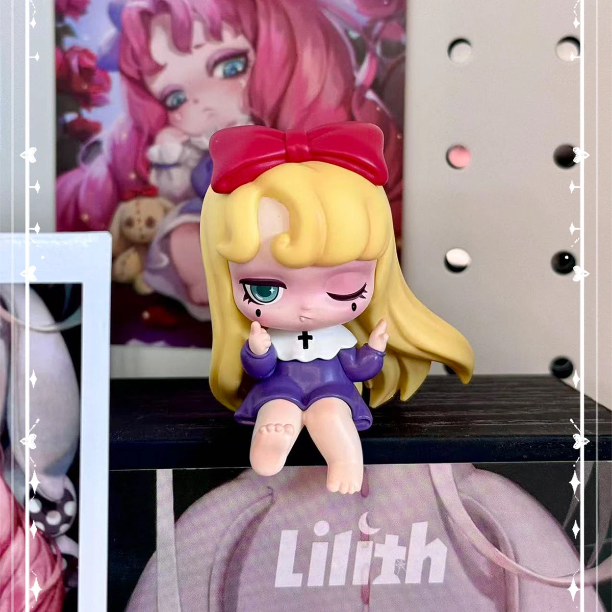 Blonde Lilith in a purple dress with red bow seated on a display platform