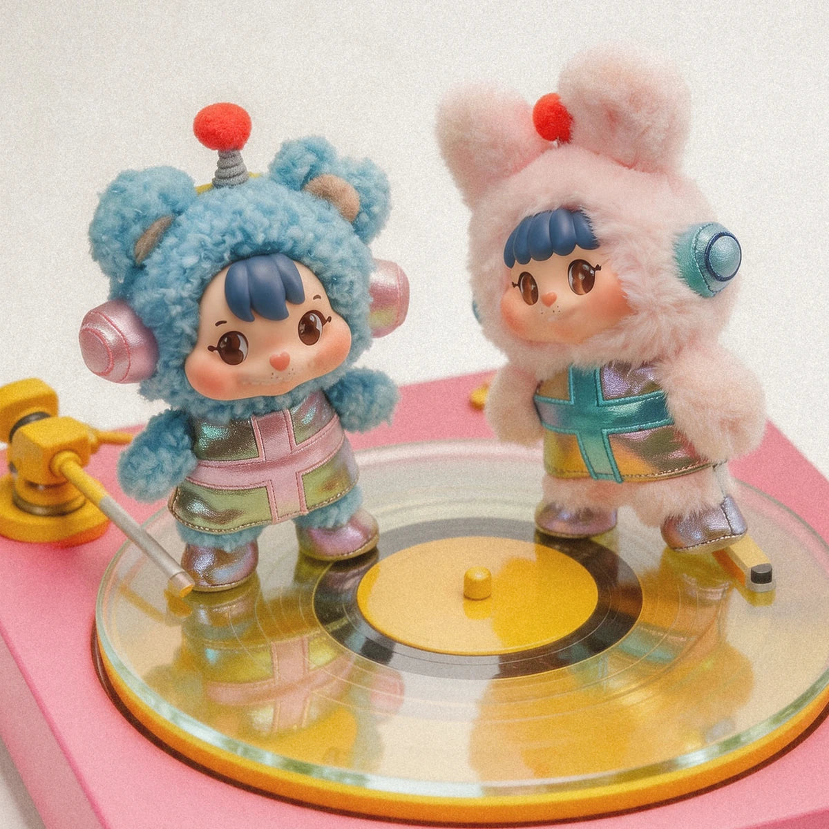 Two Little Buns space-suit plush characters standing on a transparent turntable