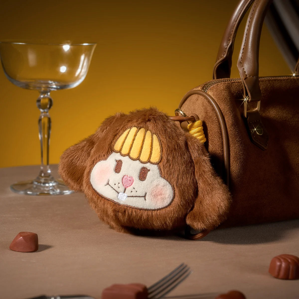 LITTLE BUNS brown bunny plush charm with smiley face leaning against a suede handbag, Melting Together theme