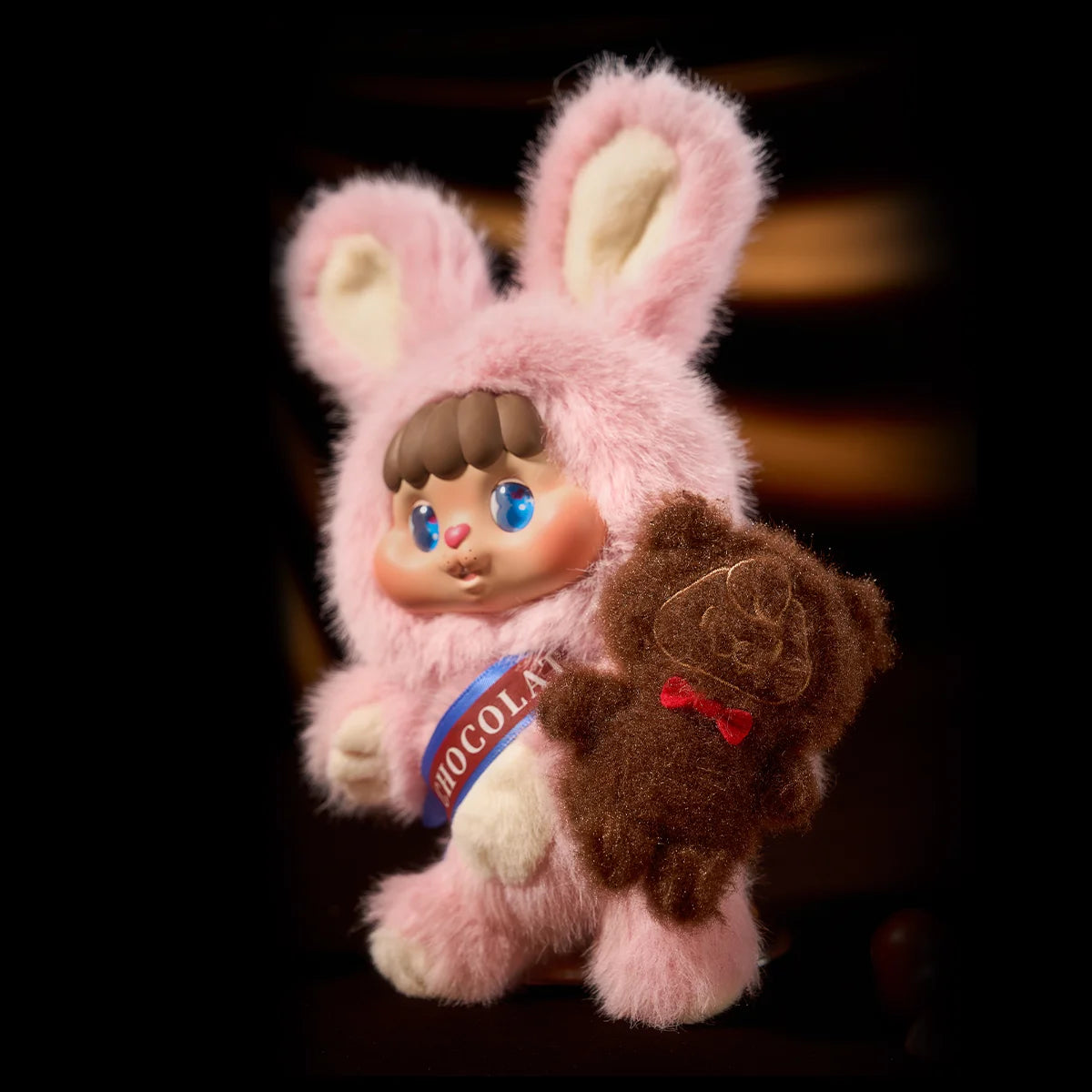 Pink strawberry Bunny Bing holding a chocolate Bear Face on dark backdrop, Little Buns Melting Together secret