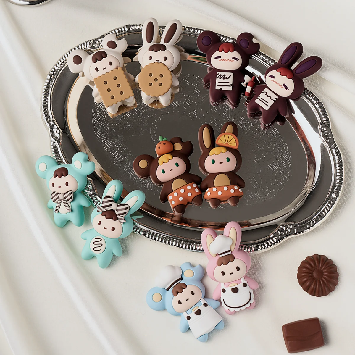 Assorted Little Buns chocolate-flavor fridge magnets scattered on a silver tray, Melting Together blind box