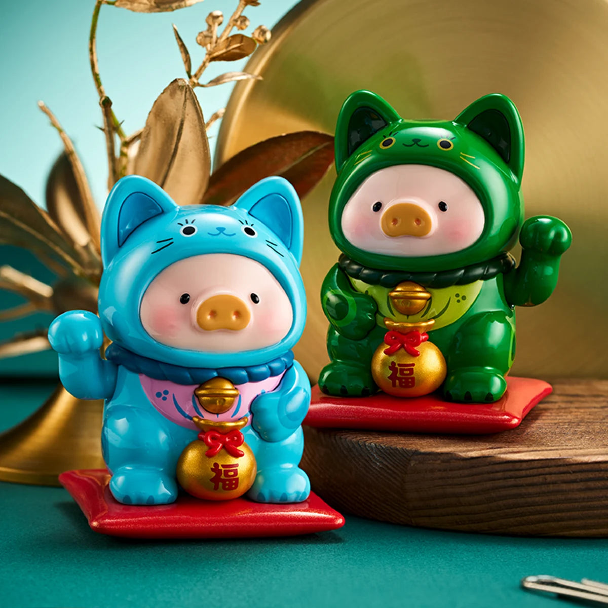 White and blue lucky-cat pigs raising paws on red cushions, LuLu the Piggy Lucky Cat Series