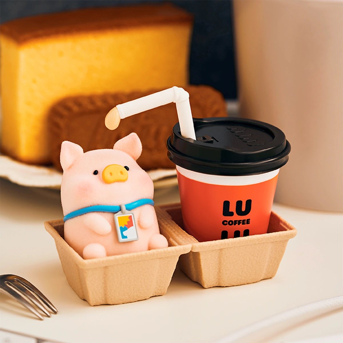 Tea Break Lu piggy in a tray box beside a red LU Coffee cup, LuLu Piggy Office