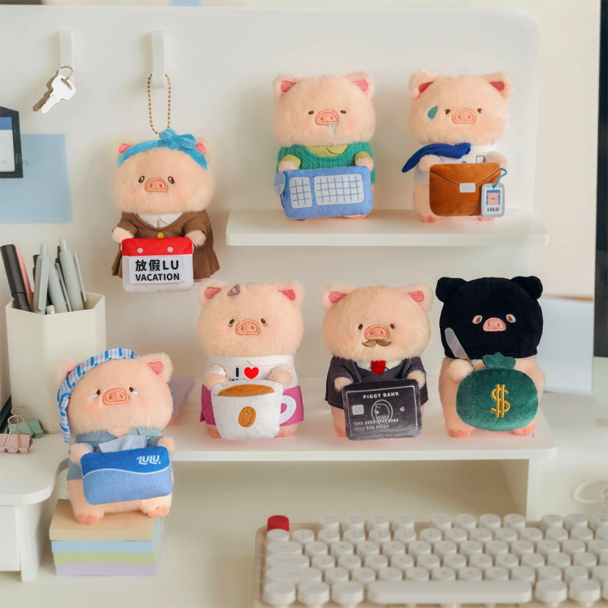 All seven LuLu Piggy Office plush keychains perched on a desk shelf, workplace blind box