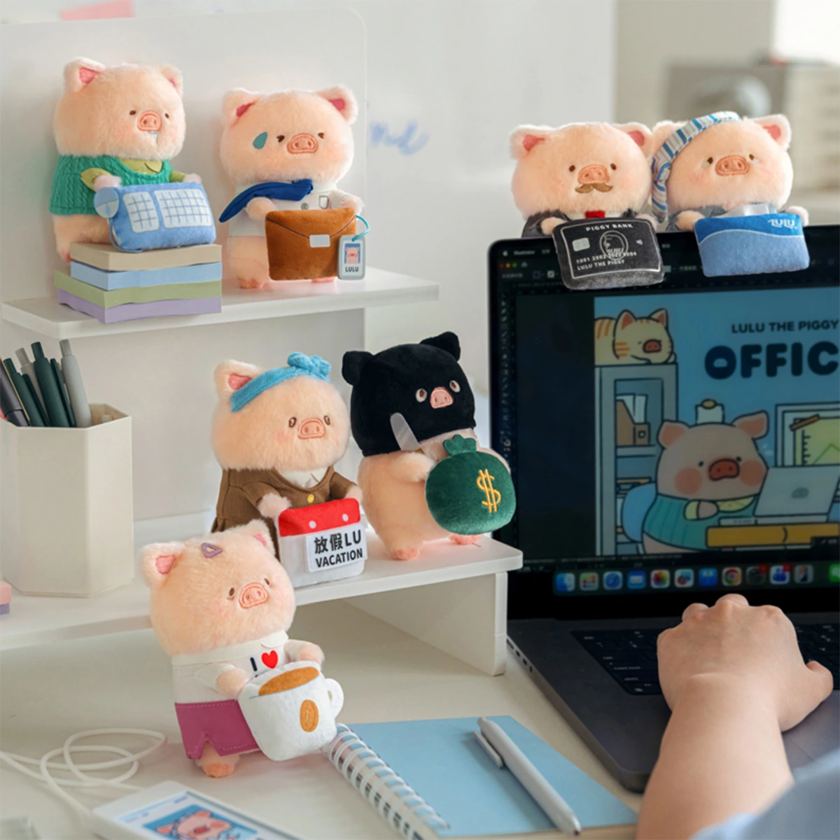 LuLu Piggy Office plush keychains arranged around a laptop desk, workplace blind box