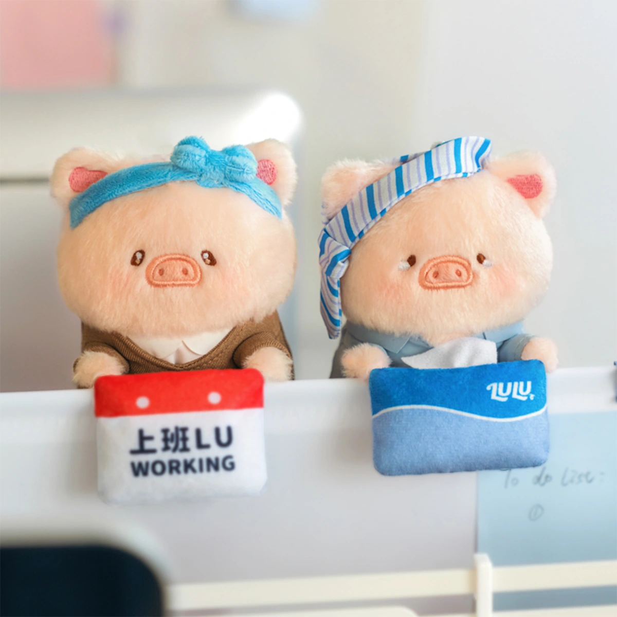 Recharge Lu and Going To Pieces Lu plush keychains with headbands on a monitor, LuLu Piggy Office