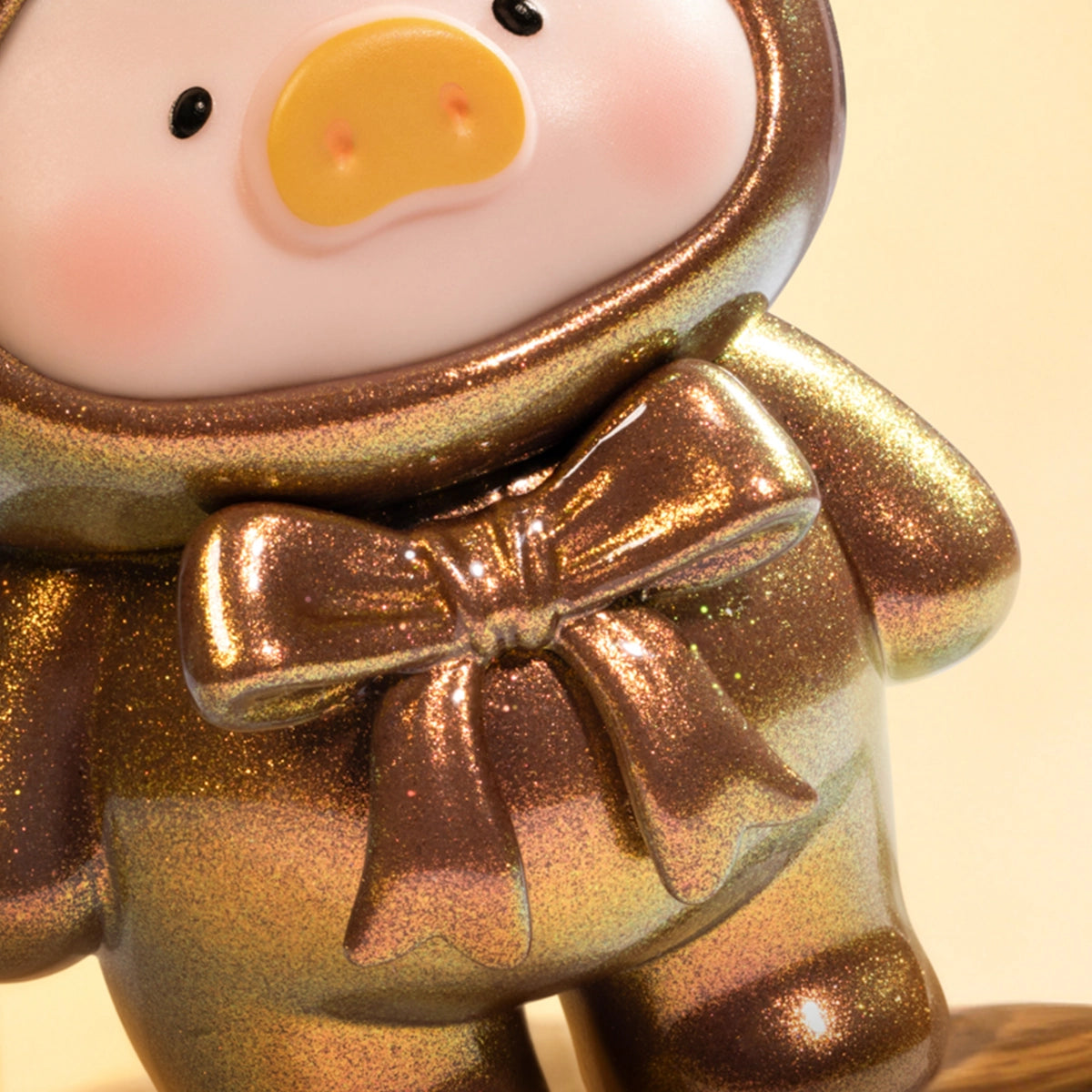 Close-up of a glittery gold-brown Tiger's Eye Lulu piggy figure with shimmering bow, Ore Collection