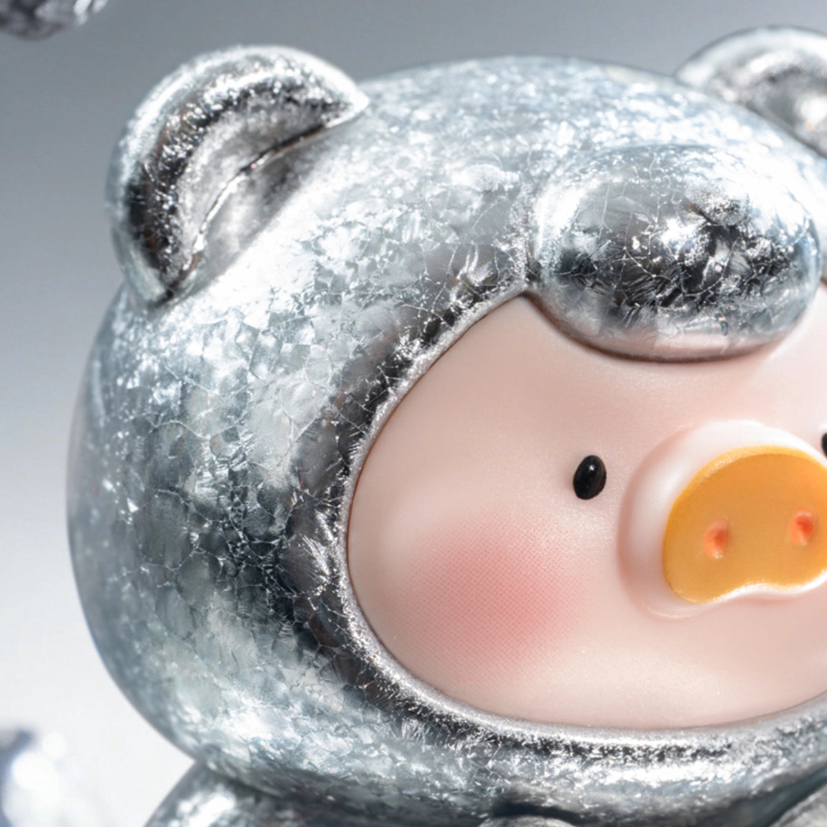 Close-up of a frosted silver Meteorite Lulu piggy figure face, Teddy Mini Ore Collection