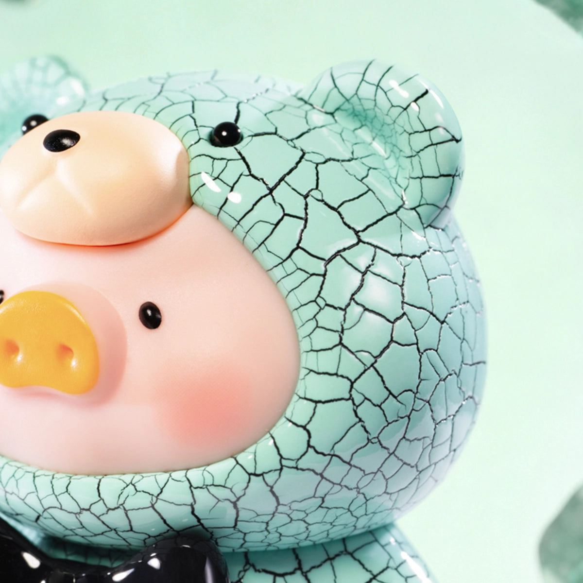 Close-up of a Turquoise crackle-textured Lulu piggy figure face and hood, Teddy Mini Ore Collection