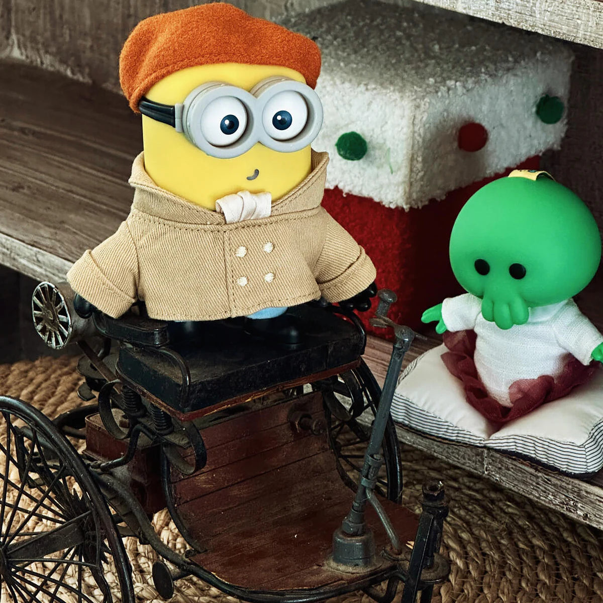 Artist Henry Minion and Goomi plush toys posed with a miniature antique bicycle