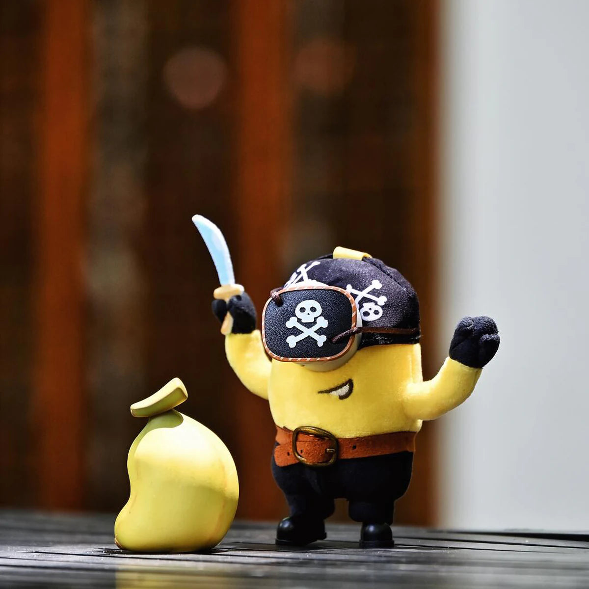 Pirate Carl Minion plush raising a sword beside a yellow money bag