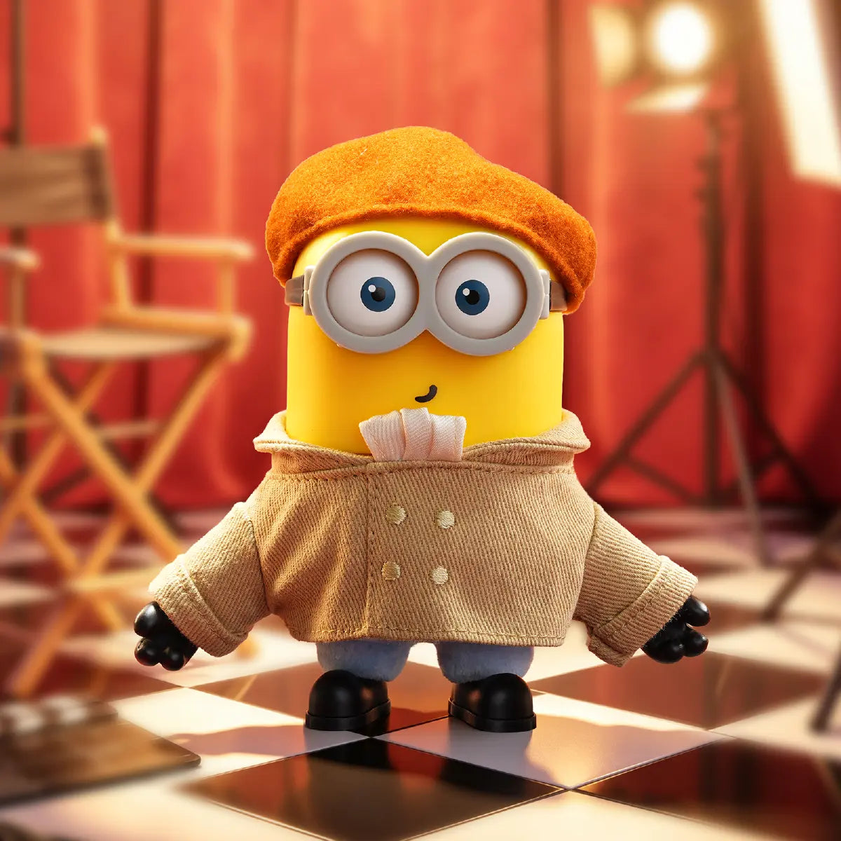 Artist Henry Minion plush in an orange beret and tan artist smock on a film set