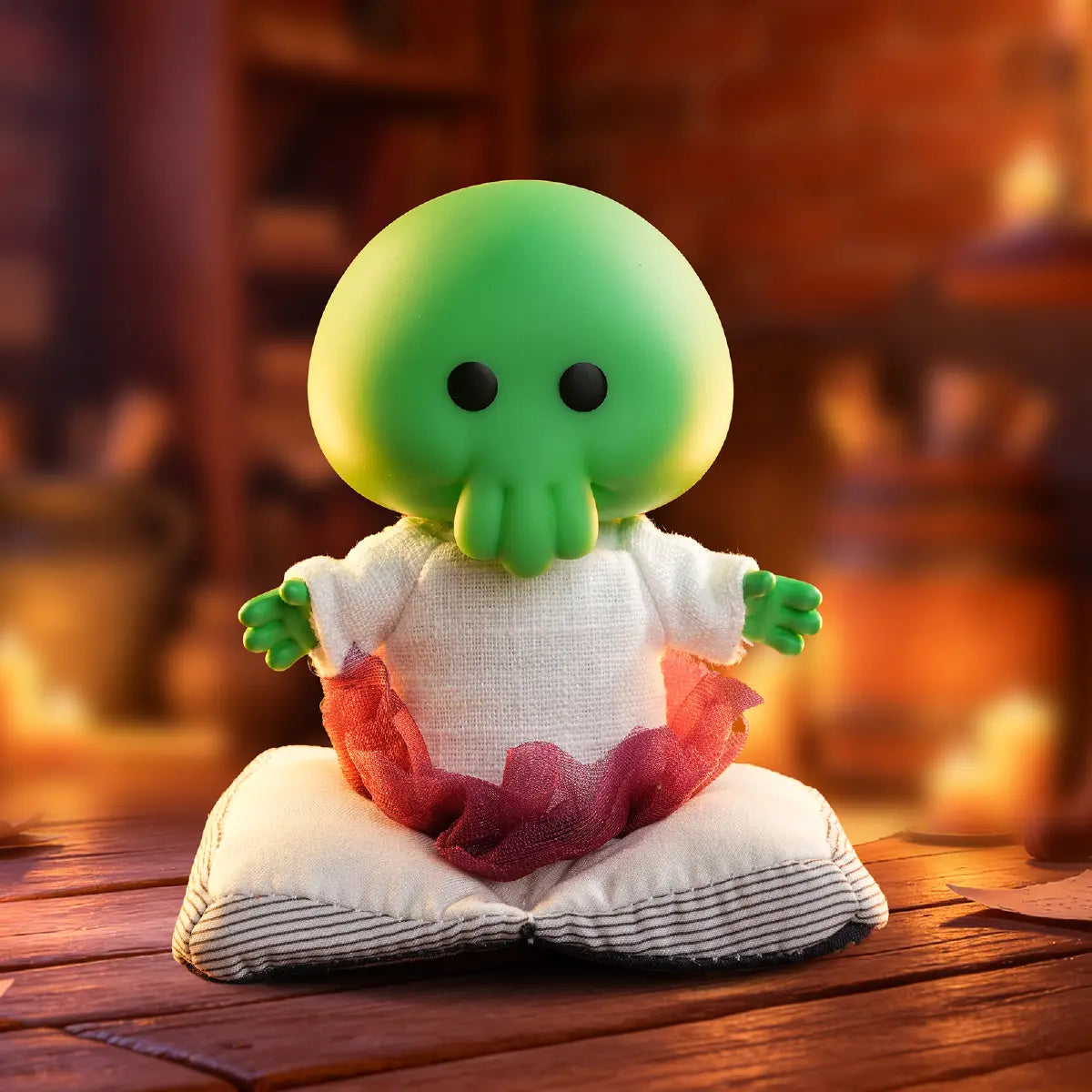 Goomi green monster plush seated on an open book in a warm study