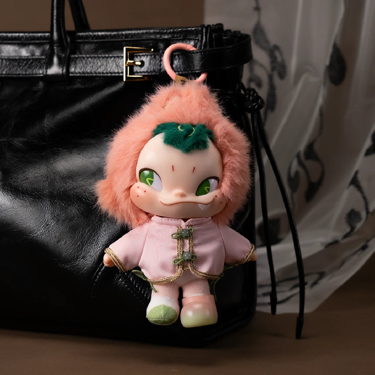 NINNIC Fairy Peach plush figure attached to a black bag in a fashion display