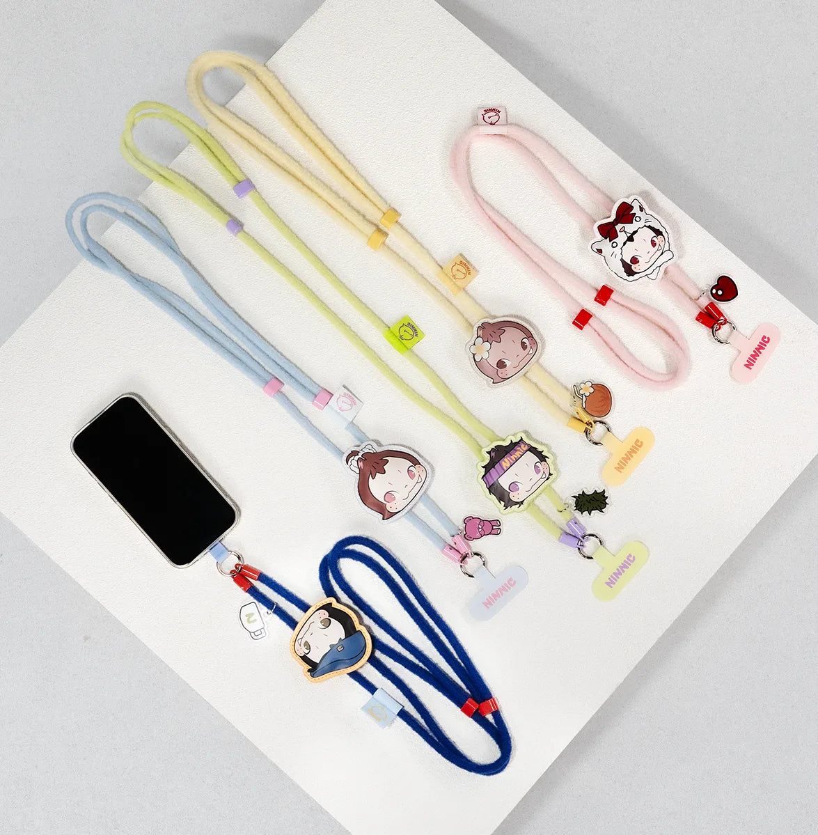 Full lineup of NINNIC Wild & Free ID-card phone strap lanyards in assorted colors with a phone, blind box