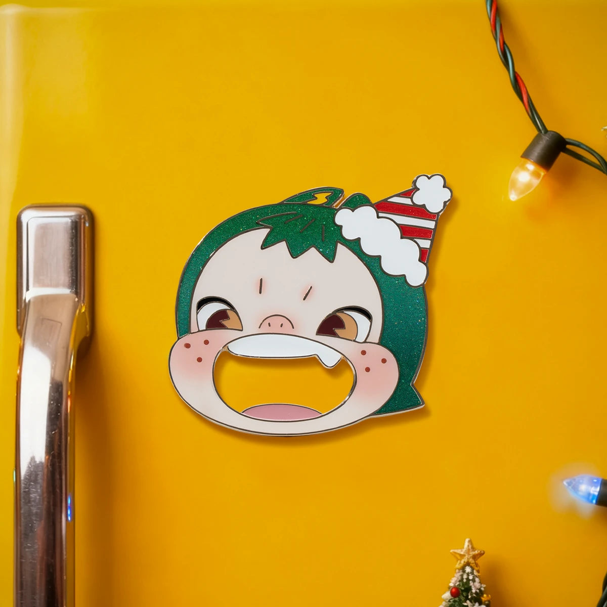 Holiday-hat face bottle opener on a yellow fridge with string lights, the Ninnic Wrap Me Up Bottle Popper